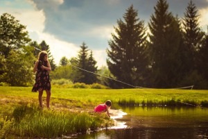 little girls fish in a pond
