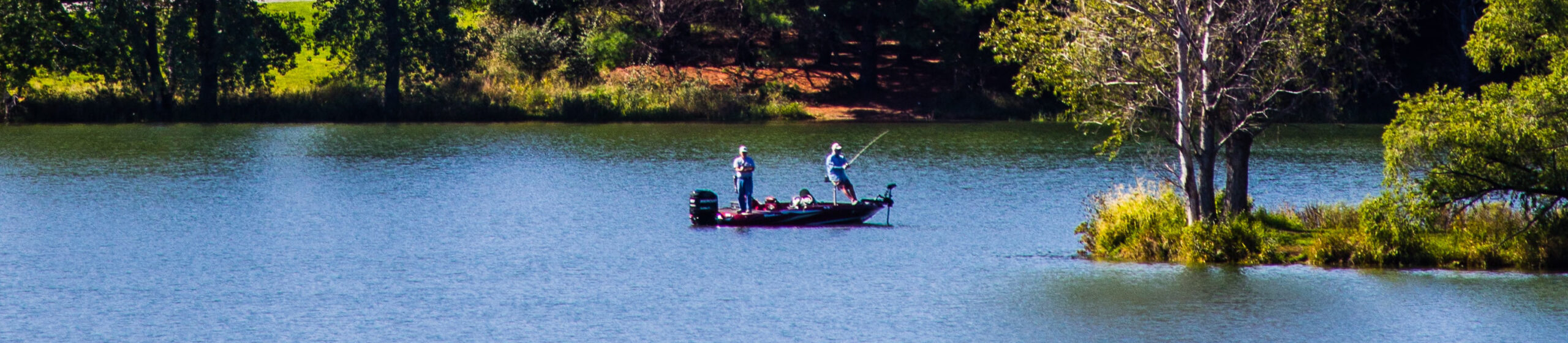 Two men out fishing on a small motor boat on a lake