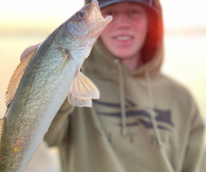 Teenage boy holding up freshly caught fish
